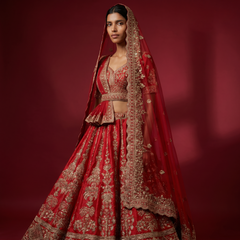 Red bridal lehenga with ornate silver embroidery and draped sheer dupatta