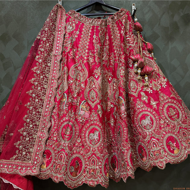 Pink lehenga with dense gold-toned embroidery, ornate scalloped hem, tassel accents