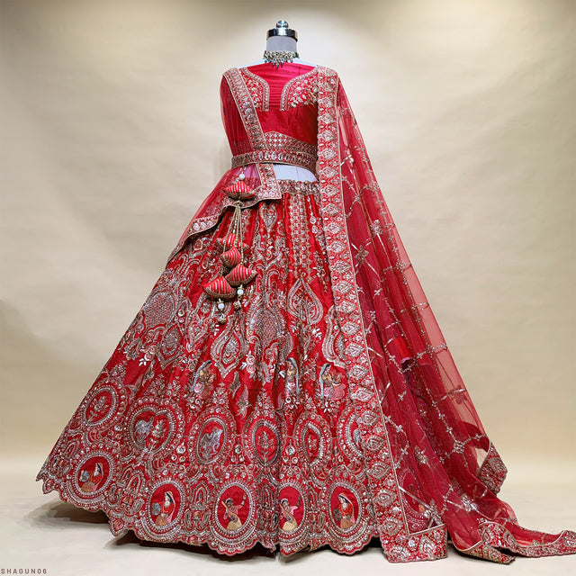 Red bridal lehenga dress on mannequin, full skirt with silver paisley embroidery and belt