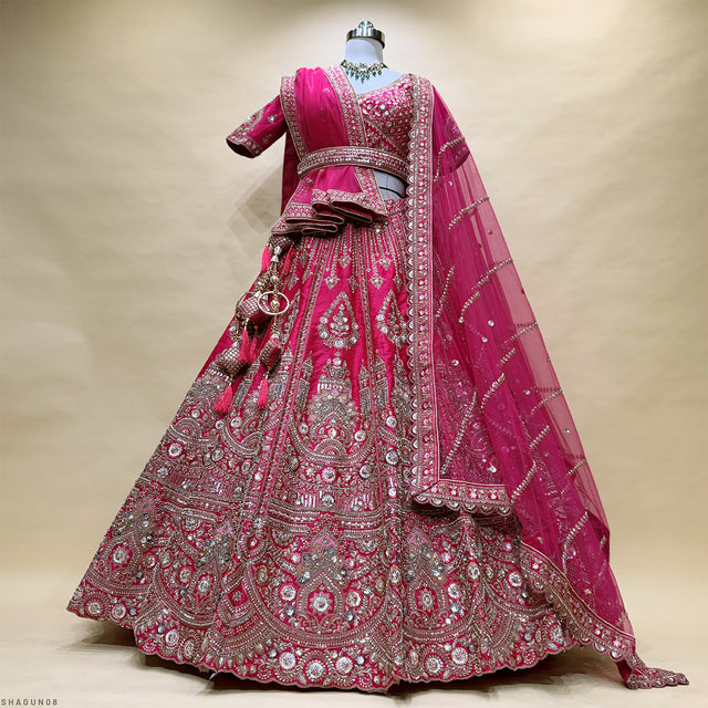 Magenta bridal lehenga with ornate silver embroidery, long-sleeve blouse and veil