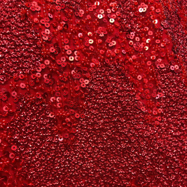 Close-up of red sequin and glitter fabric with dense overlapping sequins