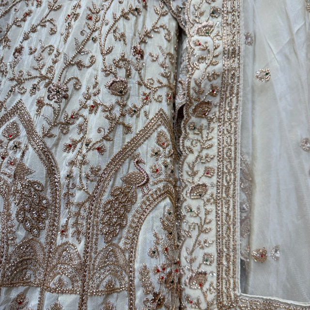 Ivory fabric close-up with gold and beaded embroidery and decorative trim