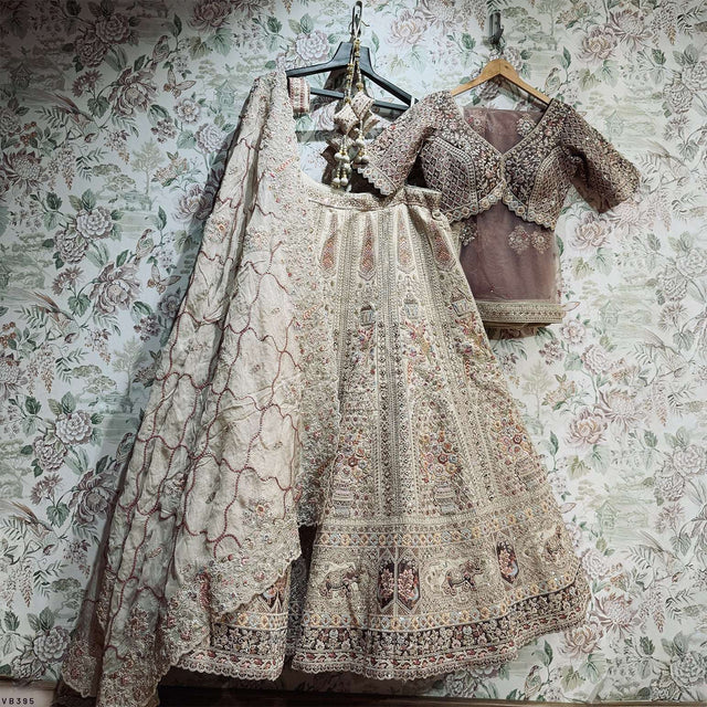 Embroidered bridal lehenga and dupatta set on hangers with ornate doriwork detailing