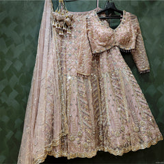 Soft pink embellished lehenga on hanger with beadwork, sequin trim, and draped dupatta