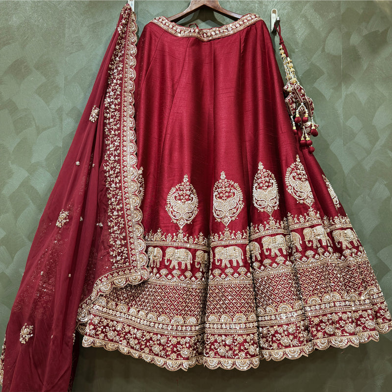 Maroon bridal lehenga front with ornate silver border and elephant motif panels