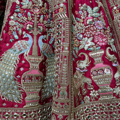 Magenta lehenga close-up with mirror beads, floral threadwork and ornate silver borders