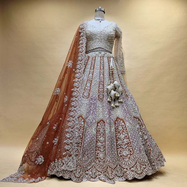 Bridal lehenga with rust orange net dupatta and ivory cutdana embroidery skirt