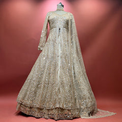 Champagne sequined net bridal lehenga gown with long sleeves and scalloped hem
