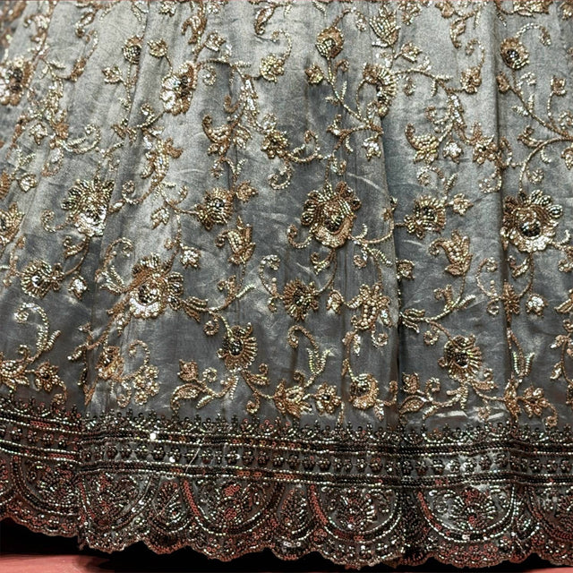 Close-up of grey tissue silk lehenga: bronze and smoke floral vines above a dark beaded scalloped border