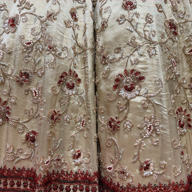 Close-up of ivory tissue silk lehenga: scrolling vines with red-filled flowers in cutdana and beadwork