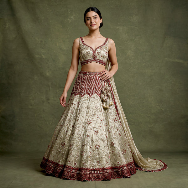 Ivory lehenga with red cutdana work and embroidered border on sleeveless top