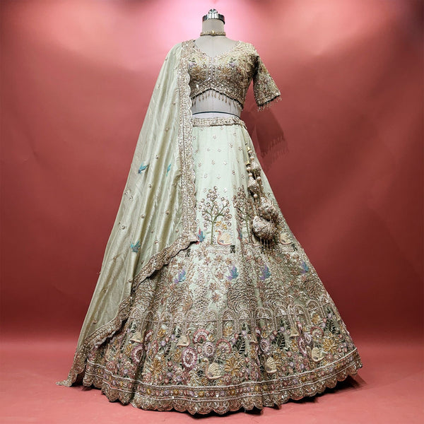 Pista green tissue silk lehenga with swan and flowering tree embroidery, scalloped hem, beaded blouse and tassels