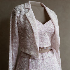 Close-up of beaded jacket with notched collar, handwork blouse with bead fringe and waistband on baby pink net