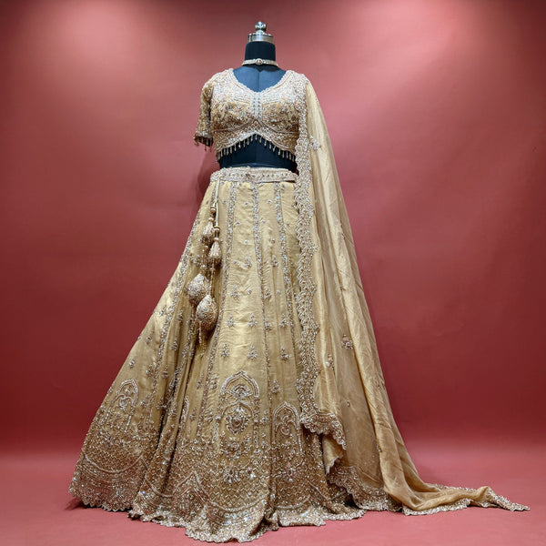 Gold handwork lehenga set with blouse, dupatta and latkans on mannequin