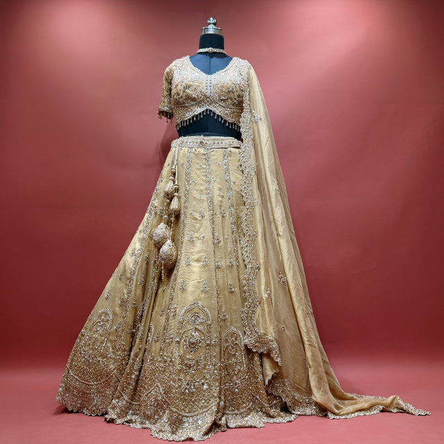 Gold handwork lehenga set with blouse, dupatta and latkans on mannequin
