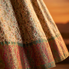 Off-white Banarasi lehenga skirt with multicolor motifs and red-green border hem