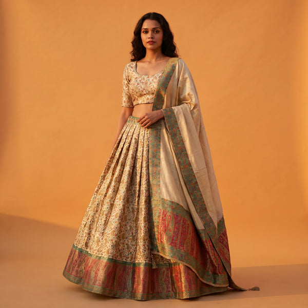 Off-white Banarasi lehenga with floral weave, multicolor border and matching blouse, dupatta drape.