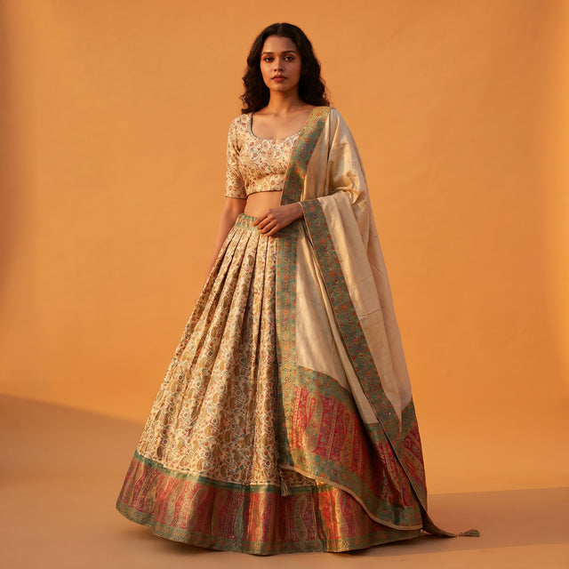 Off-white Banarasi lehenga with floral weave, multicolor border and matching blouse, dupatta drape.