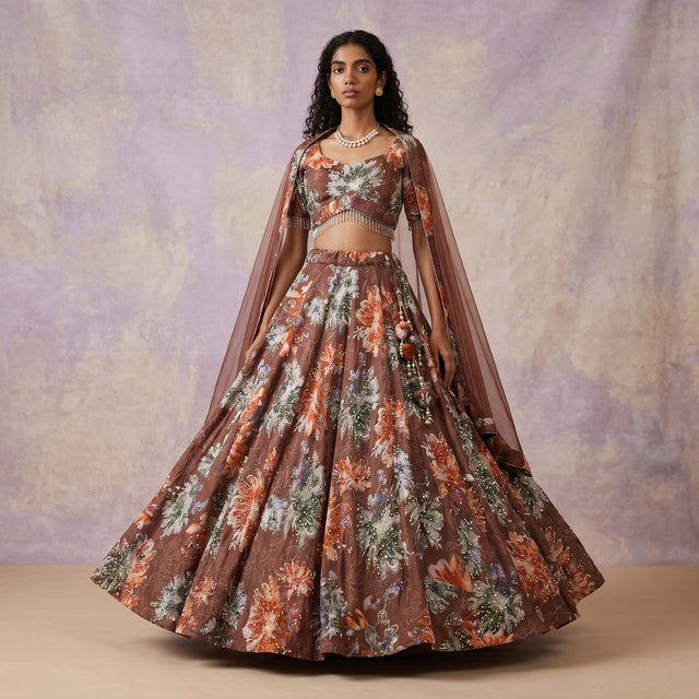 Mocha floral print lehenga with cropped blouse and sheer cape, flared skirt
