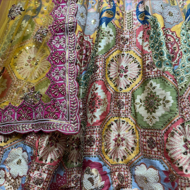 Close-up of multicolour Banarasi lehenga: octagonal medallion tiles with mirror and bead centres, fuchsia dupatta border