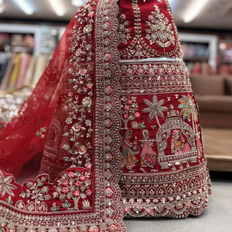 Deep red bridal lehenga skirt with ornate silver beadwork and embroidered border motifs