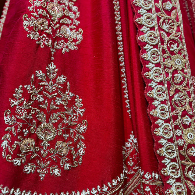 Red lehenga fabric with large floral sequin motifs and ornate silver beaded edging