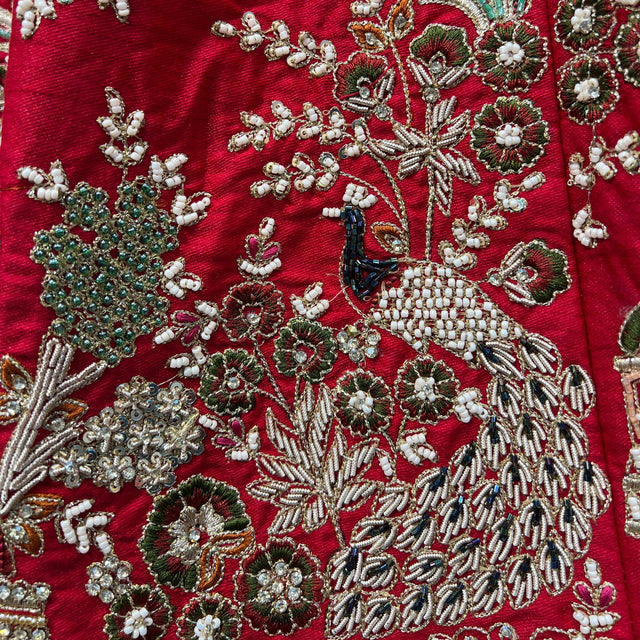Red bridal lehenga with intricate beadwork, sequins, and floral motif embroidery.