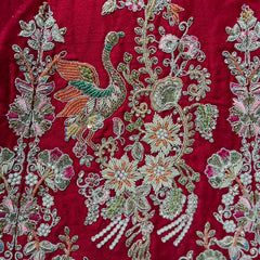 Close-up red lehenga fabric with silver, green & white beadwork and zardosi
