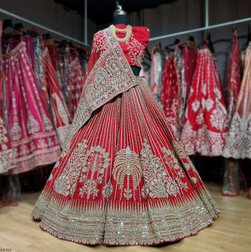 Red flared lehenga on mannequin with heavy silver-gold embroidery and embellished hem