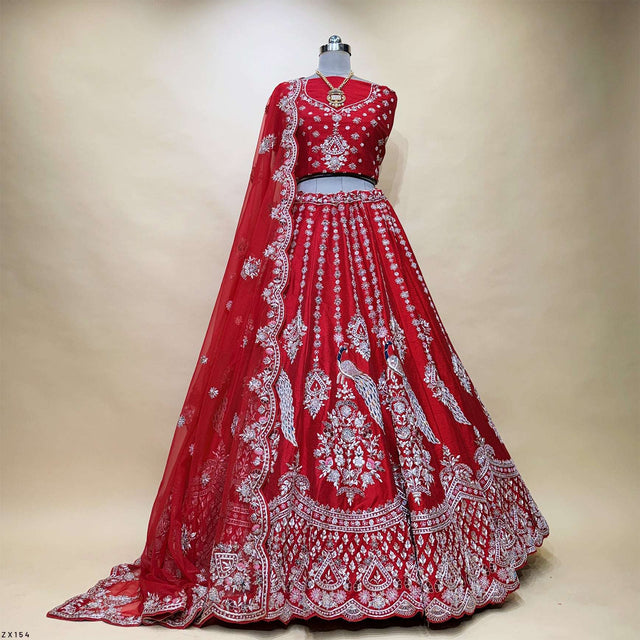 Red bridal lehenga on mannequin, with ornate silver embroidery and full skirt border