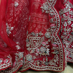 Red lehenga hem panel with silver-toned zardosi scrollwork, beads, and floral sprigs