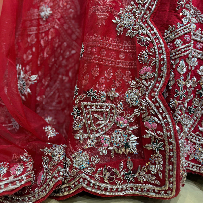 Red lehenga hem panel with silver-toned zardosi scrollwork, beads, and floral sprigs