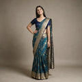 Model wearing the teal blue Banarasi art silk bandhni pattern gifting saree with zari paisley checks