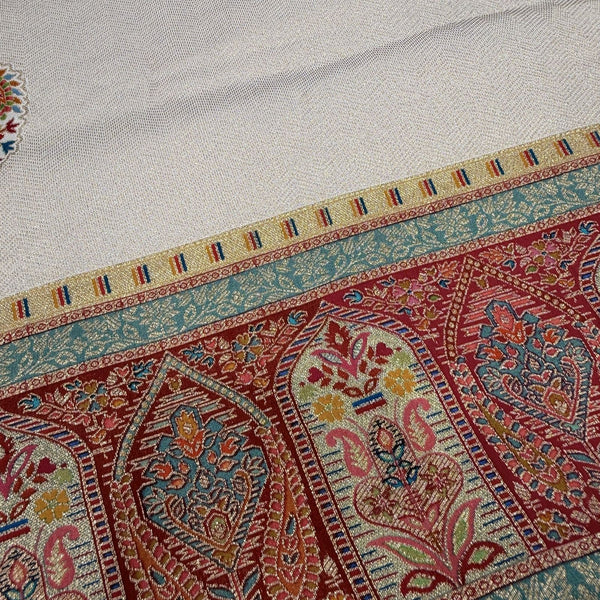 Saree border close-up with geometric arch pattern in red, teal, gold and cream