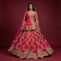 Full-length rani pink bridal lehenga with gold embroidered flared skirt and dupatta
