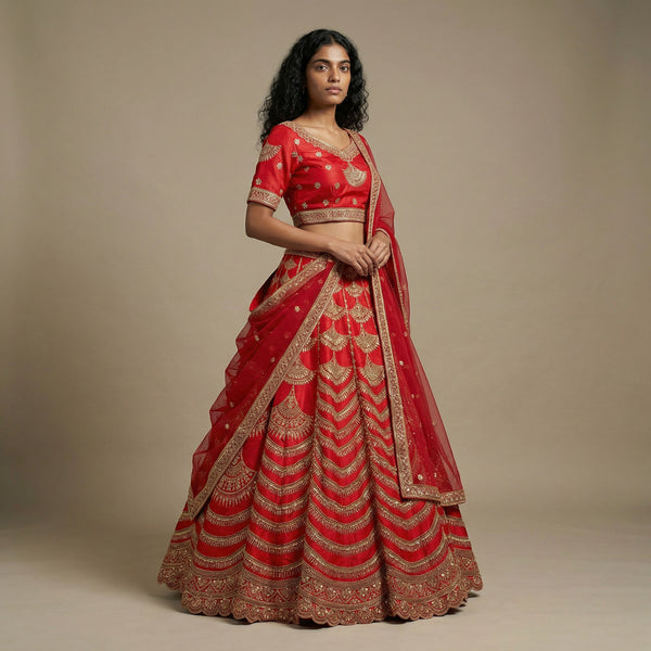 Red bridal lehenga with gold embroidered tiers and draped dupatta, short sleeves