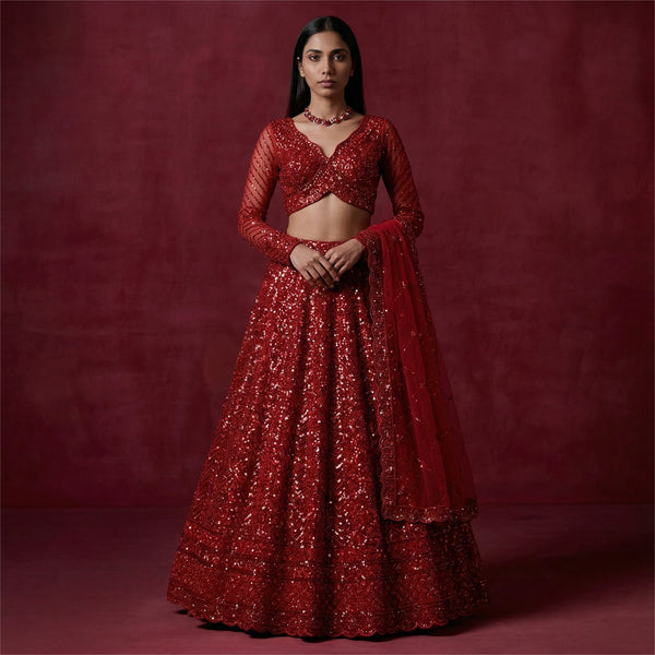 Red sequined lehenga with cropped blouse, long sleeves, and tiered flared skirt