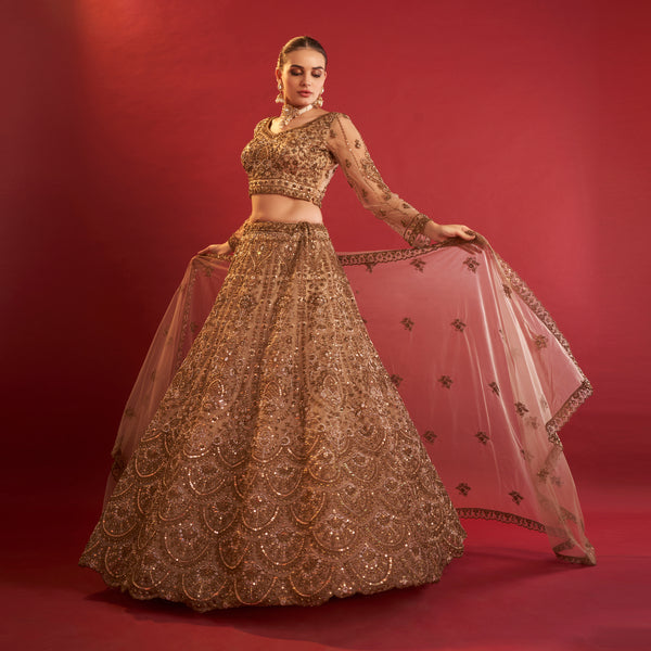 Elegant golden lehenga with beads featuring intricate embroidery and a matching choli from JMS Studio