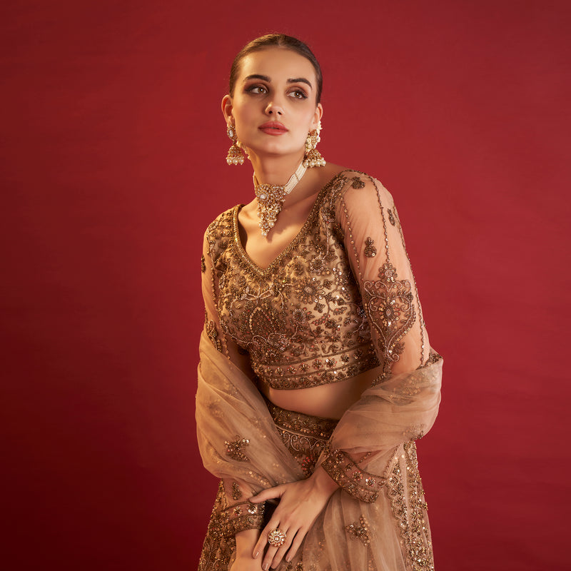 Elegant golden lehenga with beads showcasing intricate embroidery and a stylish crop top design
