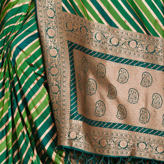 Green silk pallu close-up with paisley zari motifs and gold border