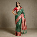 Green Banarasi Art Silk Saree with Floral Jaal, Zari Butis & Red Border, worn by a model