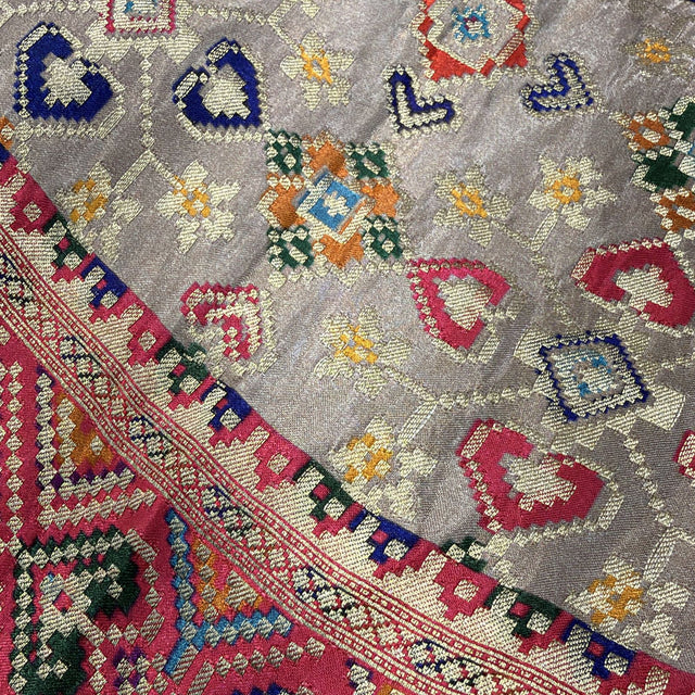 Grey viscose saree fabric close-up with diamond motifs and multicolor border strip