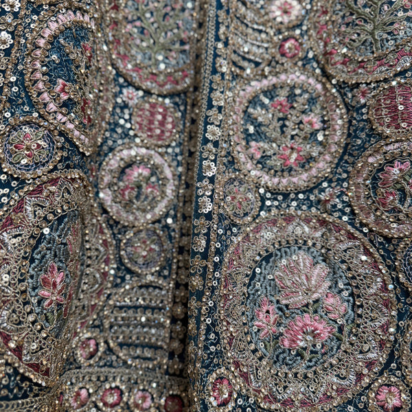 Close-up of navy-teal lehenga embroidery with sequins, beads, and pink floral motifs