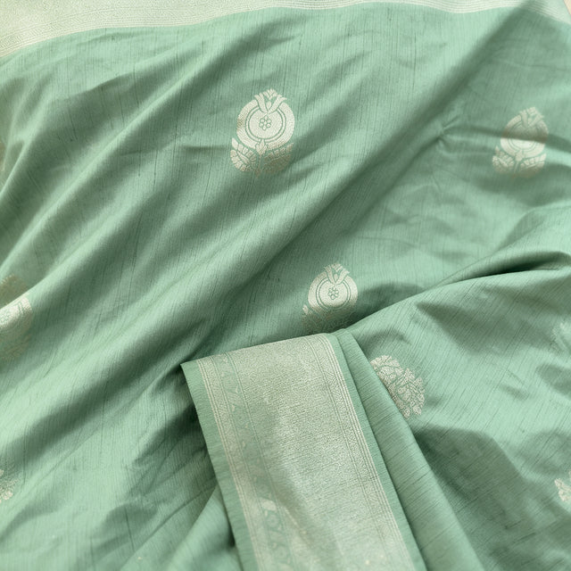 Mint green fabric close-up with zari motifs and woven border in light mint
