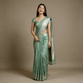 Mint green linen-cotton saree with zari butas and zari border, draped on model