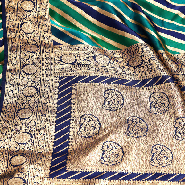 Gold zari pallu close-up with navy and teal stripes plus floral paisley motifs