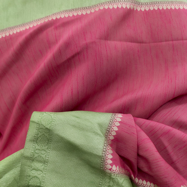 Close-up of pink saree fabric with pista green border and zari detailing