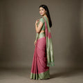 Pink linen-cotton saree with pista green zari border and draped pallu
