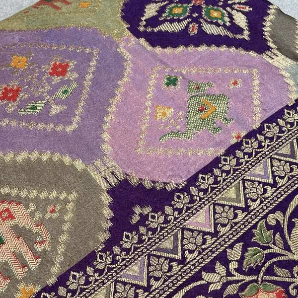 Purple saree close-up with geometric animal motifs and embellished border
