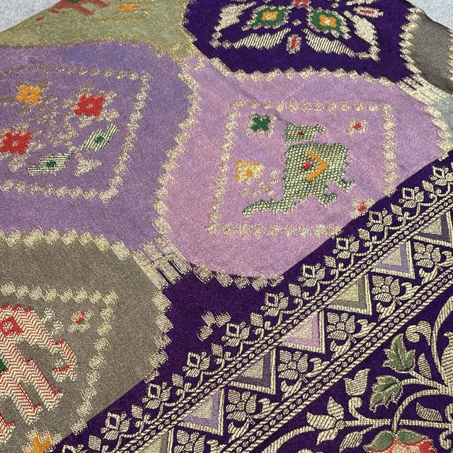 Purple saree close-up with geometric animal motifs and embellished border